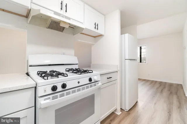 a white stove top oven sitting inside of a kitchen
