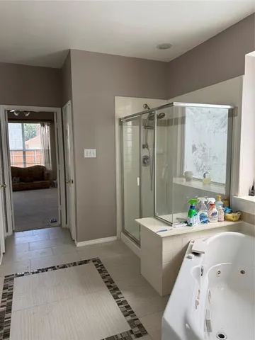 a bathroom with a granite countertop sink a mirror a bathtub and shower