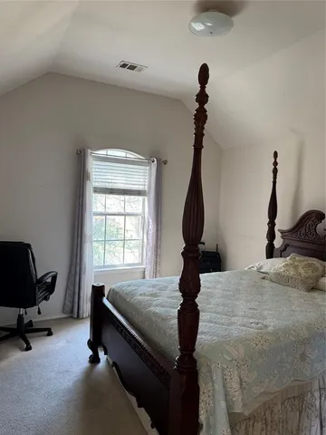 a bedroom with bed and a window