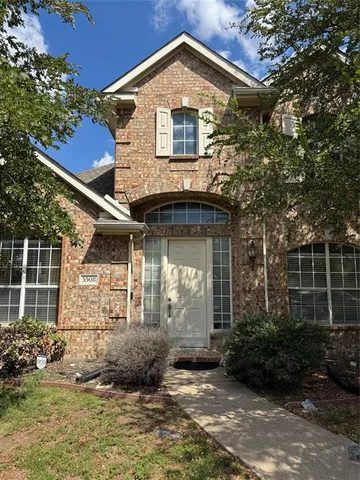 a view of a house with brick walls and flower plants