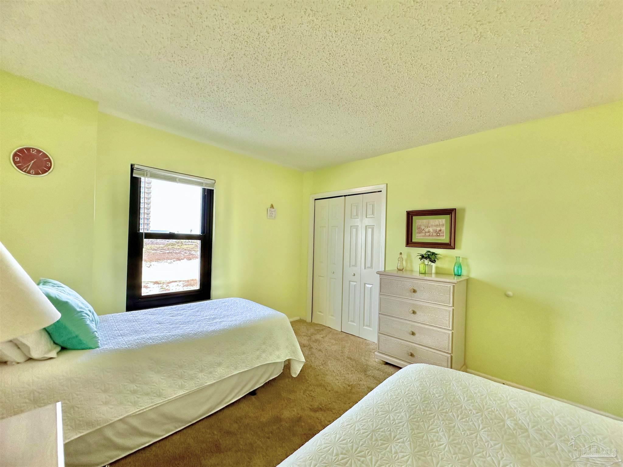 13817 Perdido Key Drive, Unit 204 Pensacola, FL 32507 - Photo 17 of 27 a bedroom with a bed and a dresser