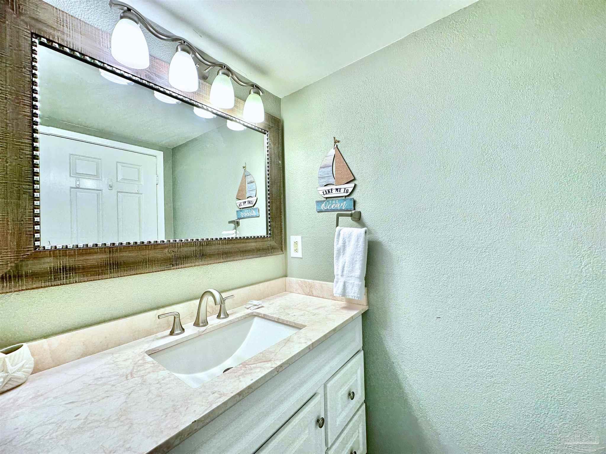 13817 Perdido Key Drive, Unit 204 Pensacola, FL 32507 - Photo 19 of 27 a bathroom with a granite countertop sink and a mirror
