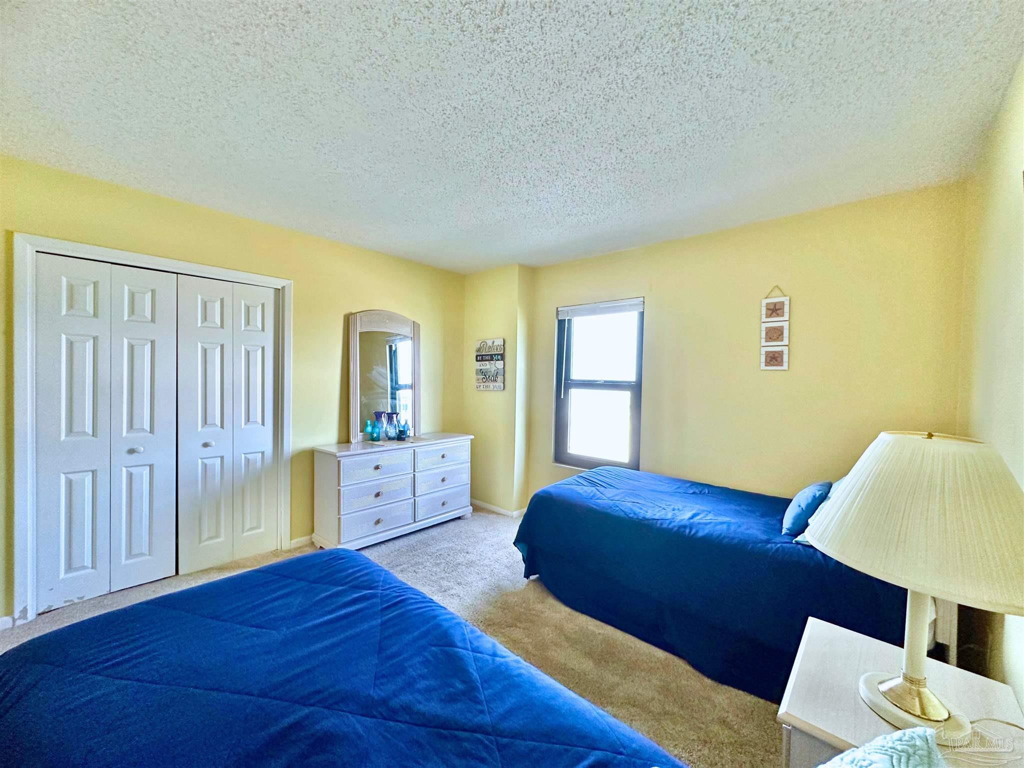 13817 Perdido Key Drive, Unit 204 Pensacola, FL 32507 - Photo 22 of 27 a bedroom with a bed and wooden floor