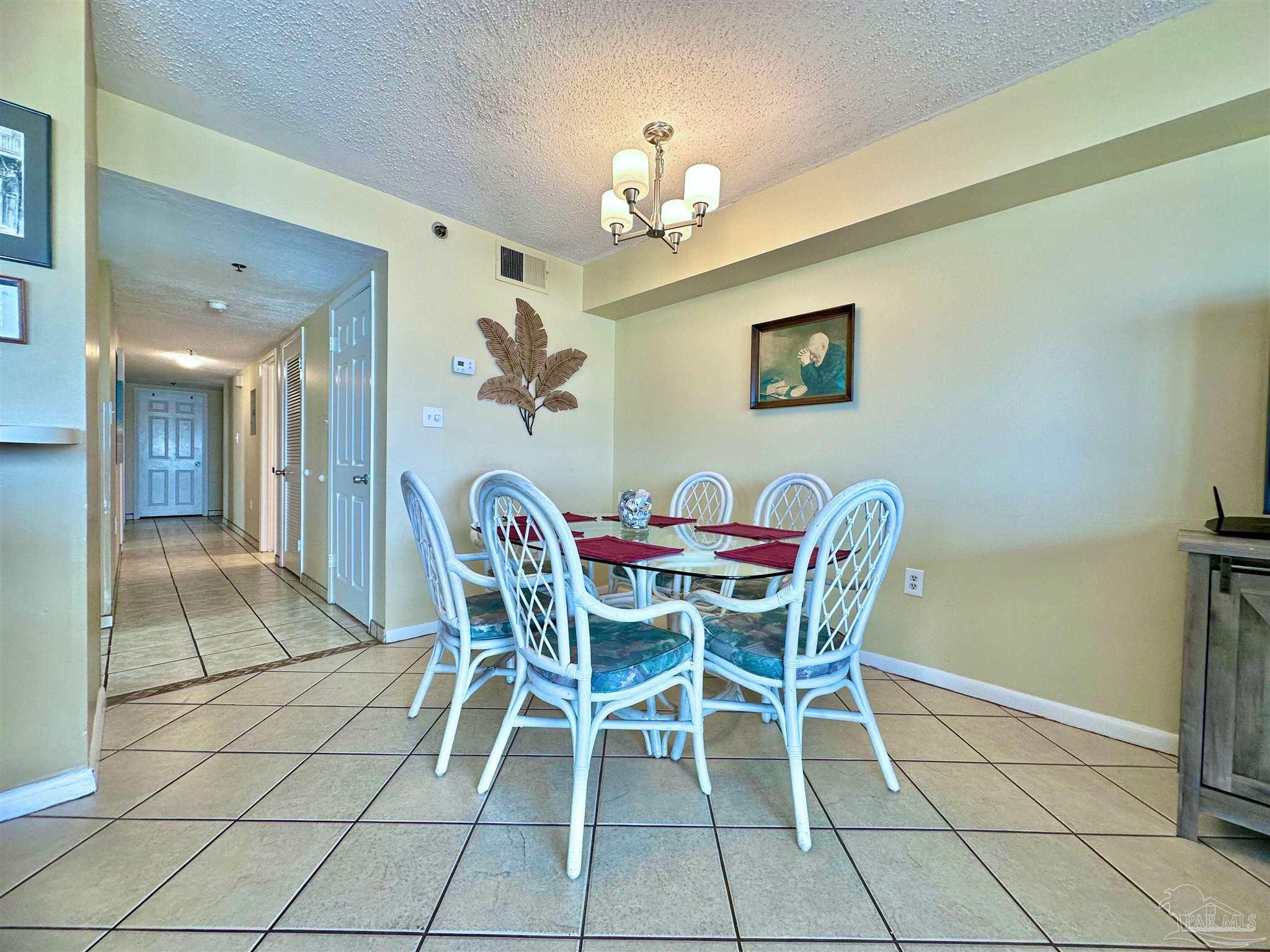 13817 Perdido Key Drive, Unit 204 Pensacola, FL 32507 - Photo 6 of 27 a dining room with furniture and chandelier