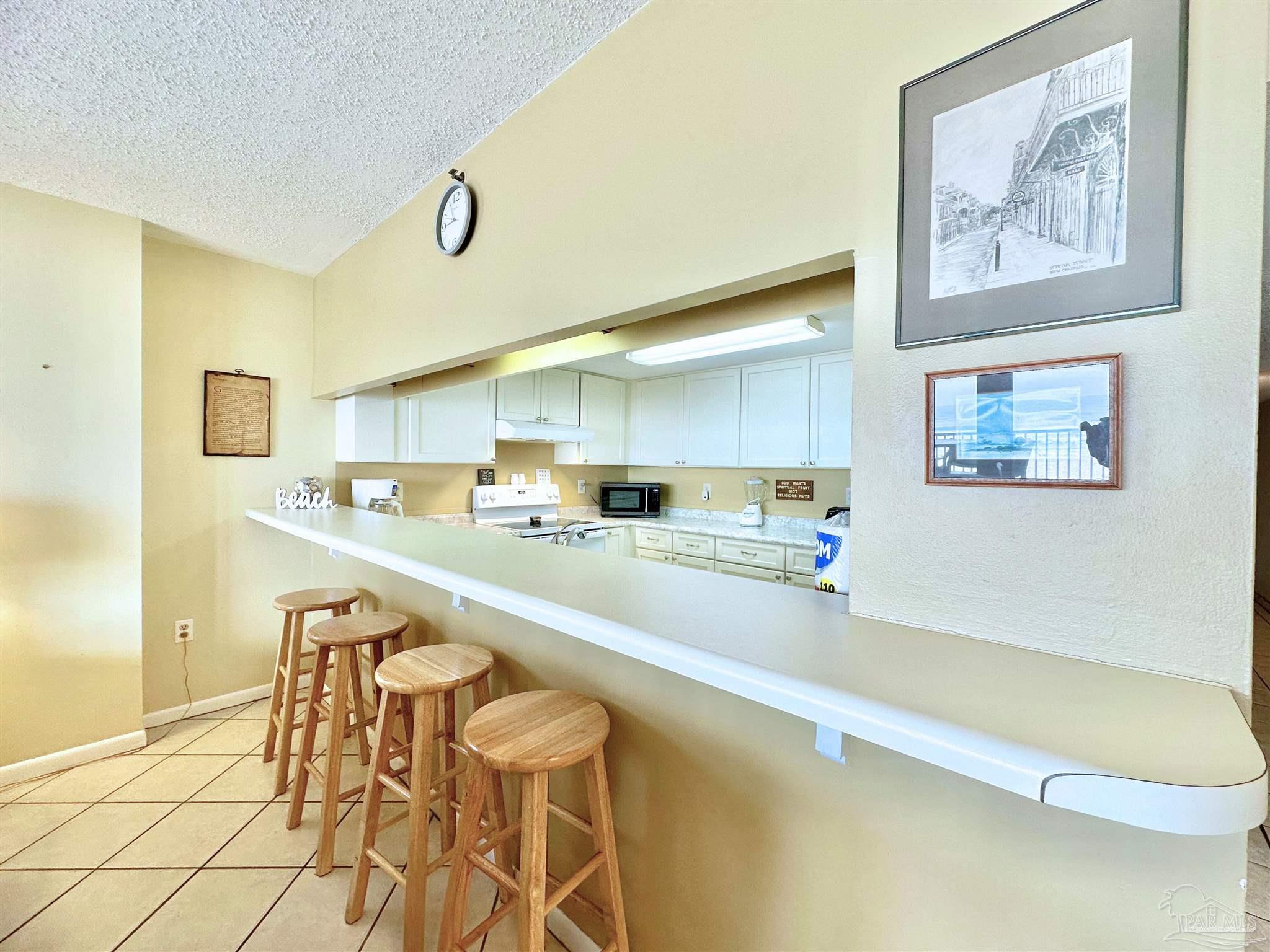 13817 Perdido Key Drive, Unit 204 Pensacola, FL 32507 - Photo 8 of 27 a large white kitchen with wooden floor and a sink