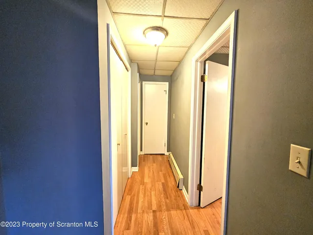 a view of a hallway with wooden floor