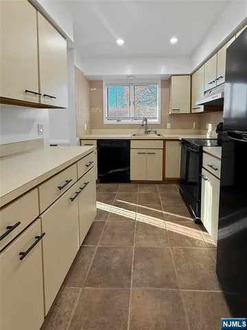 a kitchen with a sink a stove and cabinets