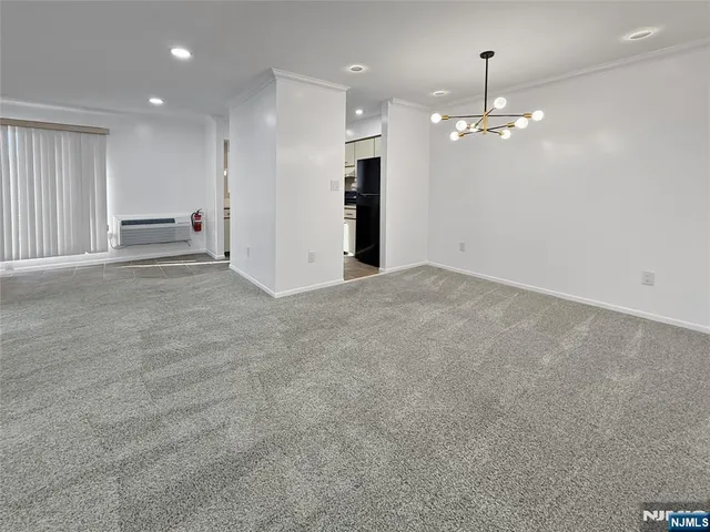 a view of an empty room and kitchen view