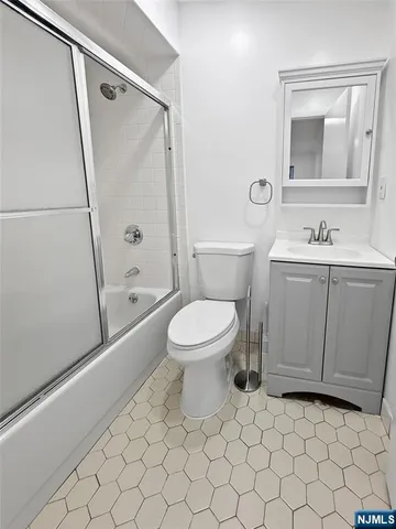 a bathroom with a toilet sink vanity and mirror