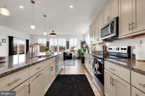 a large kitchen with stainless steel appliances lots of counter space and a sink