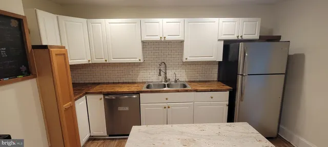 a kitchen with appliances a sink and cabinets