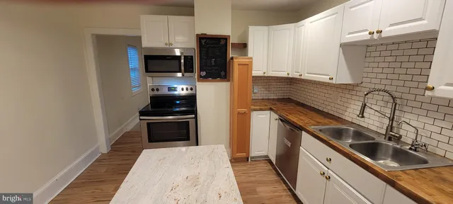 a kitchen with a sink and steel appliances