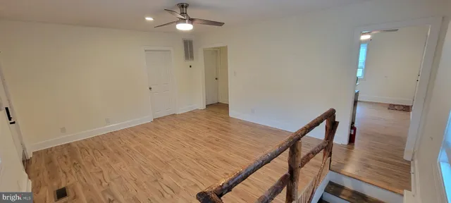 a view of a hallway with wooden floor and staircase