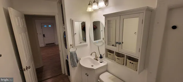 a bathroom with a sink vanity mirror and toilet