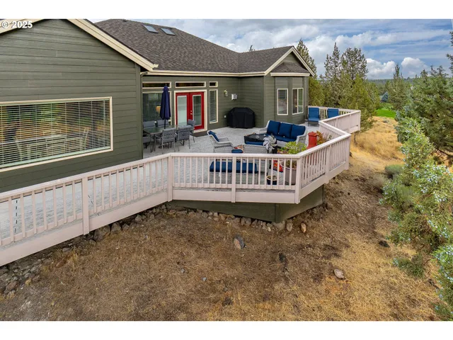 a view of a house with a wooden deck and furniture