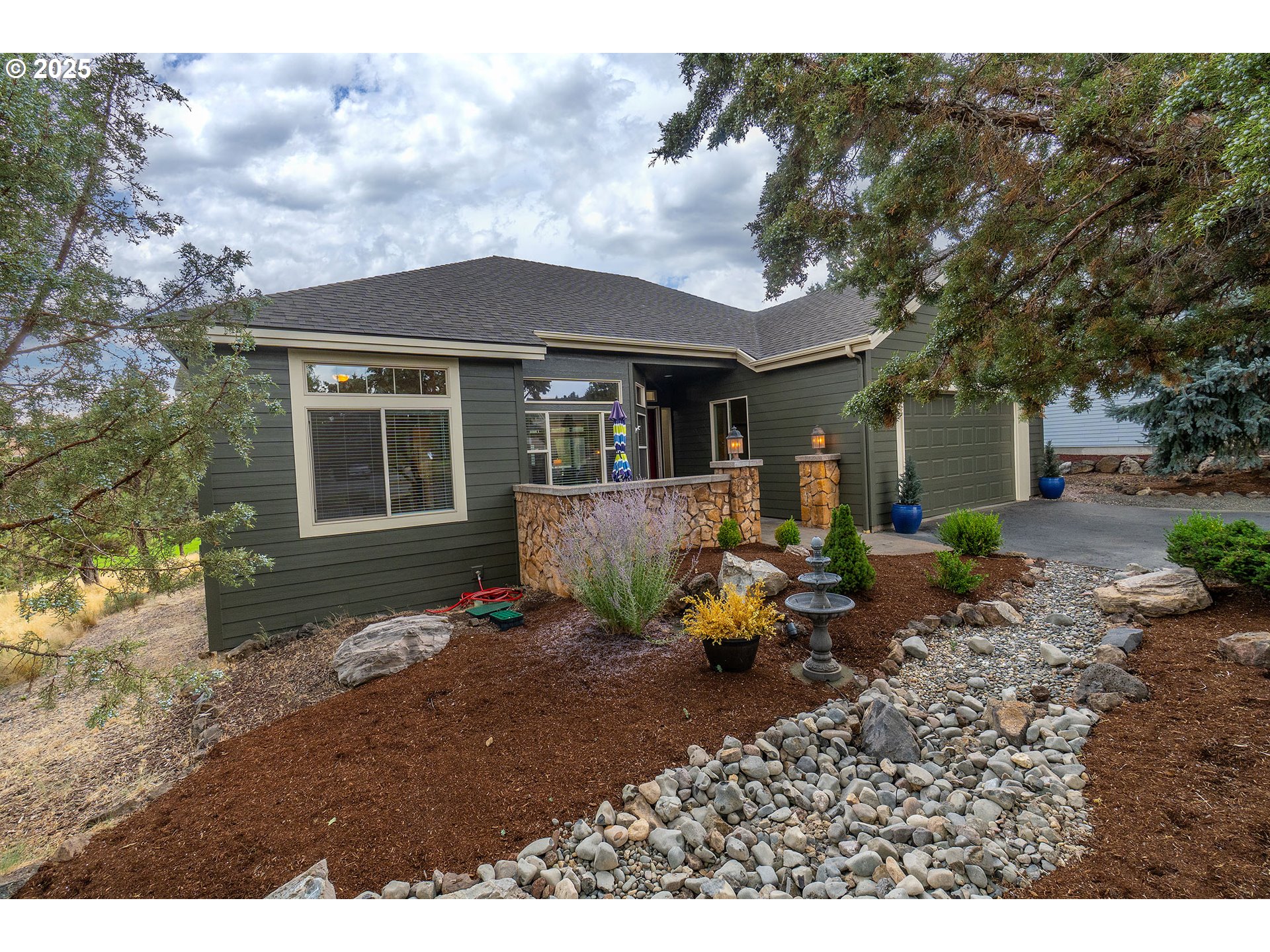 7986 Little Falls Court Redmond, OR 97756 - Photo 2 of 32 a backyard of a house with table and chairs