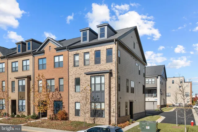 a front view of a residential apartment building with a yard