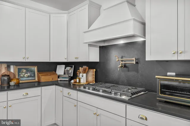 a large bed sitting in a bedroom next to a window with a potted plant on the dresser