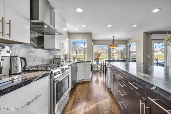 a kitchen with stainless steel appliances granite countertop sink stove top oven and cabinets