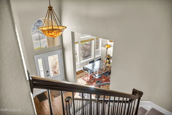 a bedroom with two beds and a large mirror next to a window
