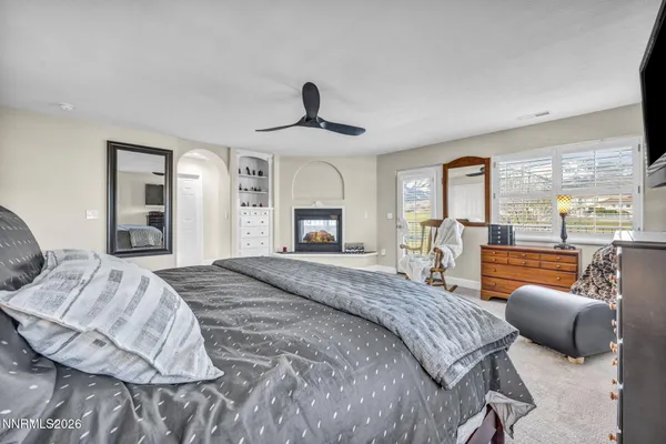a bedroom with a large bed and a flat tv screen on dresser