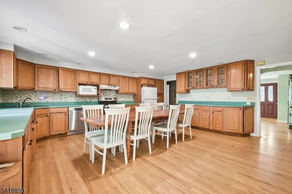 a kitchen with stainless steel appliances kitchen island granite countertop wooden floors and large window