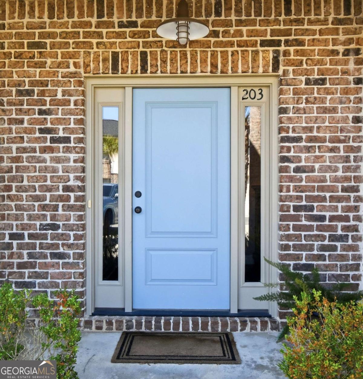203 Mariners Circle St. Simons, GA 31522 - Photo 2 of 32 a front view of a building with a garden