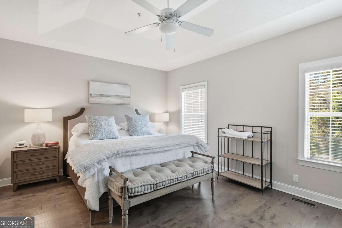 203 Mariners Circle St. Simons, GA 31522 - Photo 21 of 32 a bedroom with a bed a dresser and a chandelier