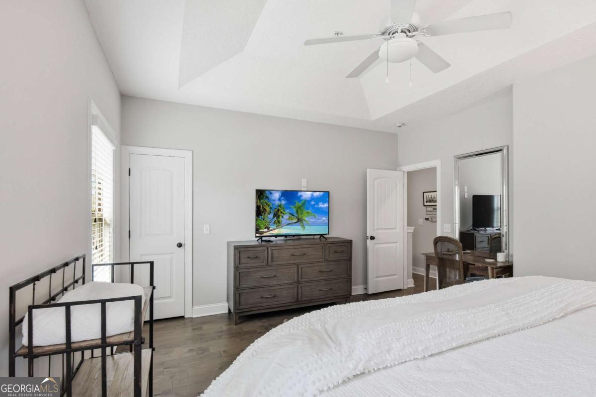 203 Mariners Circle St. Simons, GA 31522 - Photo 22 of 32 a bedroom with furniture and a flat screen tv