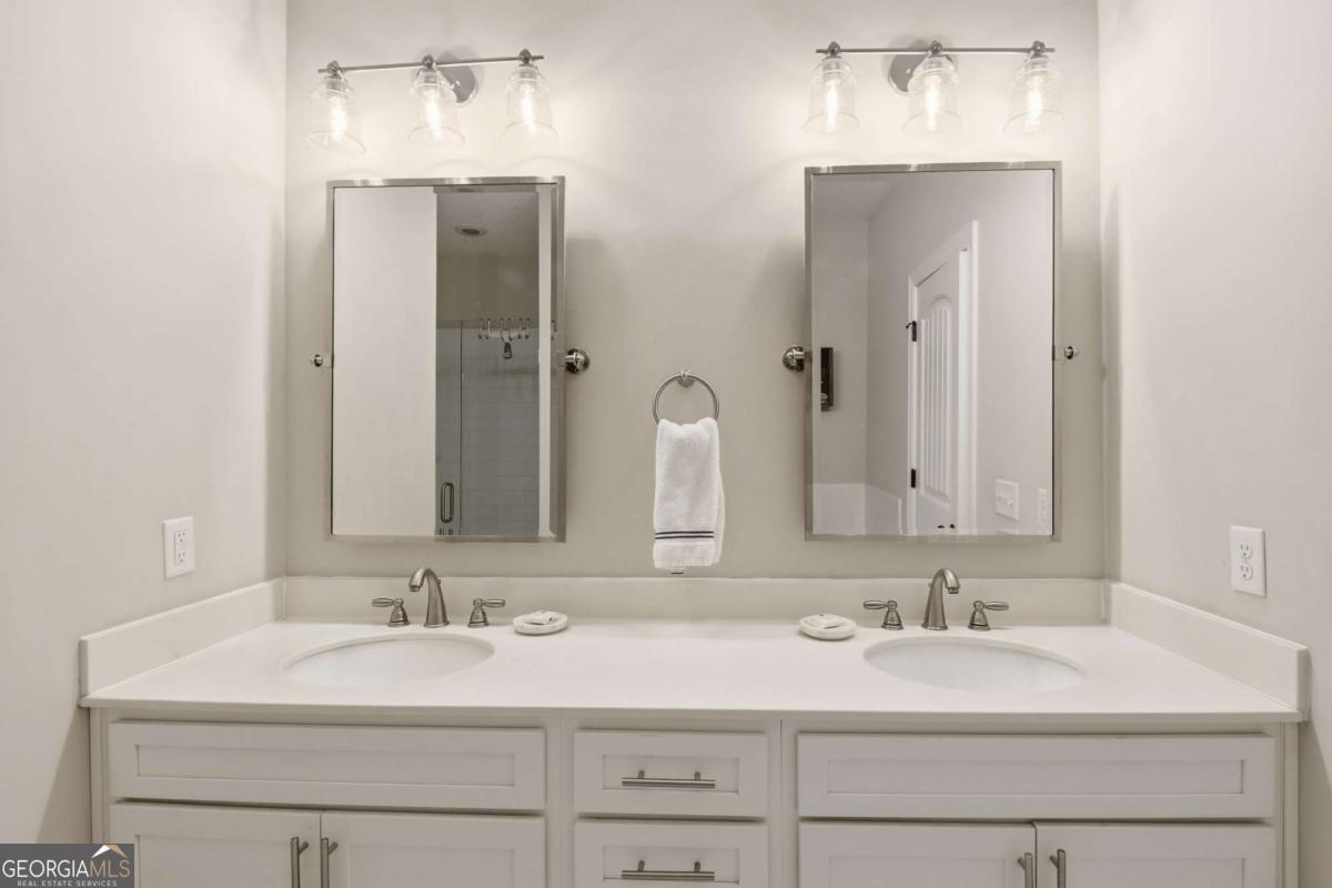 203 Mariners Circle St. Simons, GA 31522 - Photo 23 of 32 a bathroom with double sink and a mirror