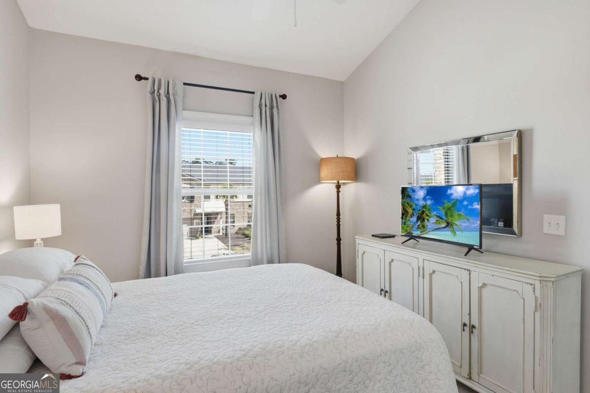 203 Mariners Circle St. Simons, GA 31522 - Photo 30 of 32 a bedroom with a bed and a flat screen tv