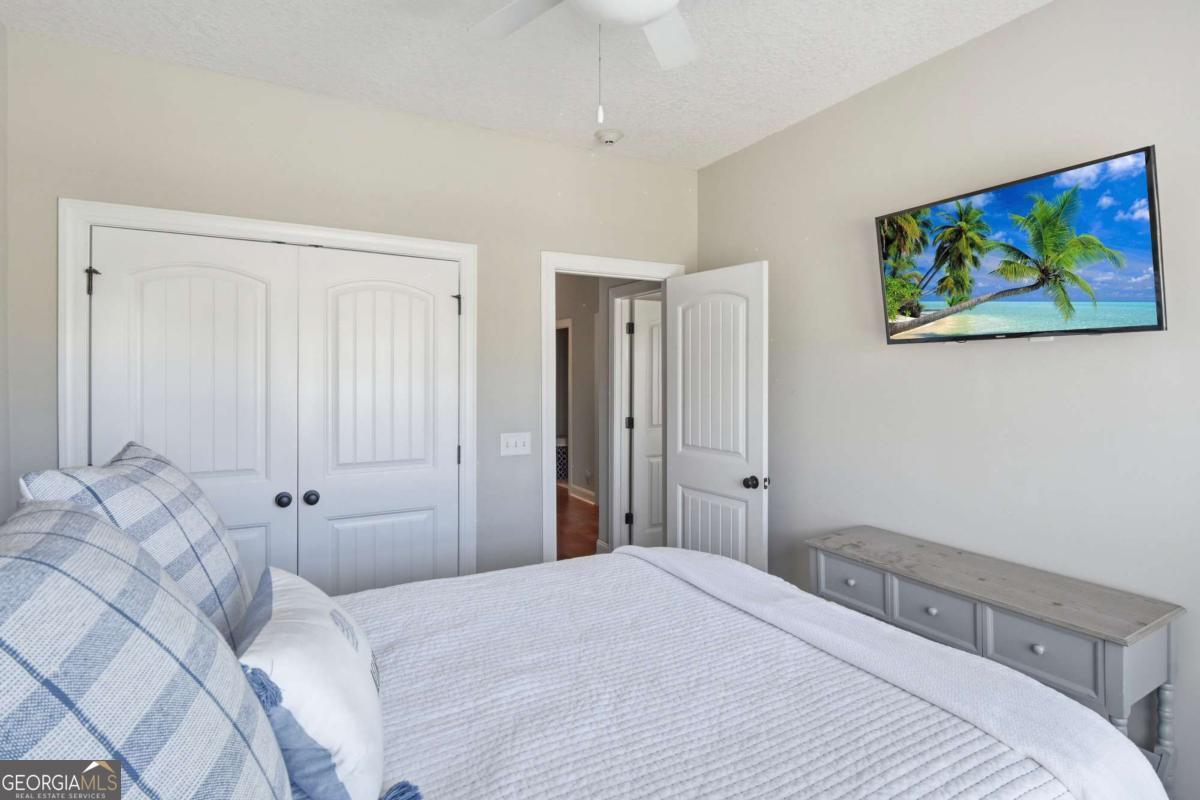 203 Mariners Circle St. Simons, GA 31522 - Photo 32 of 32 a bedroom with a bed and a painting on the wall