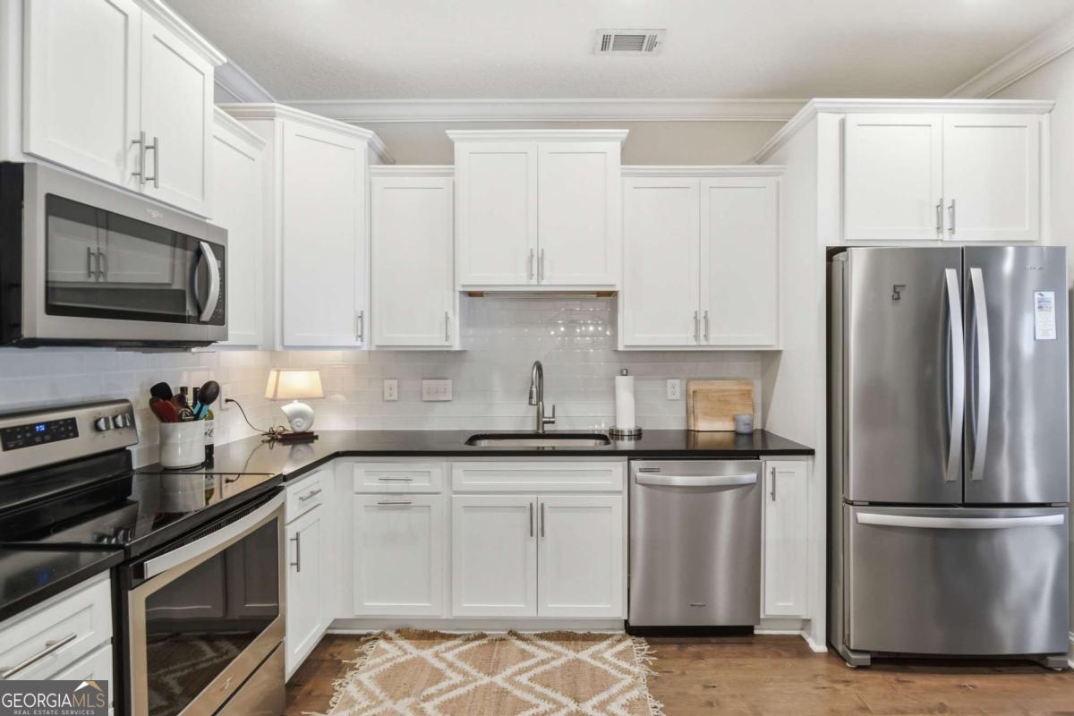 203 Mariners Circle St. Simons, GA 31522 - Photo 8 of 32 a kitchen with cabinets stainless steel appliances and a counter space