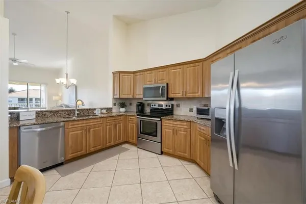 a kitchen with stainless steel appliances granite countertop a refrigerator sink and cabinets