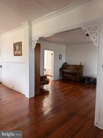 a view of a hallway with wooden floor and windows
