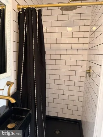 a bathroom with a tub a sink a window and a shower