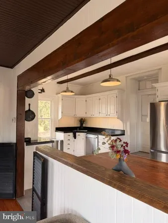 a kitchen with stainless steel appliances granite countertop a sink a stove and a refrigerator
