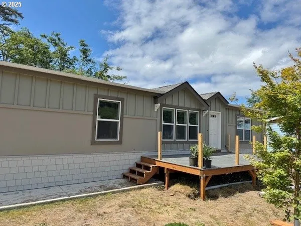 a front view of a house with a yard and wooden fence