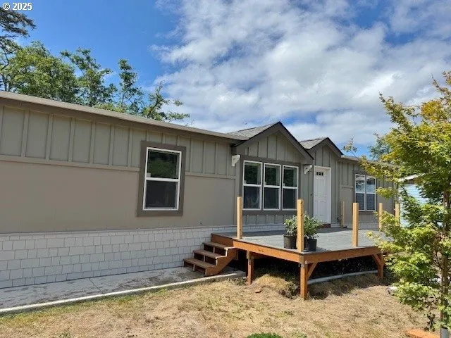 a front view of a house with a yard and wooden fence