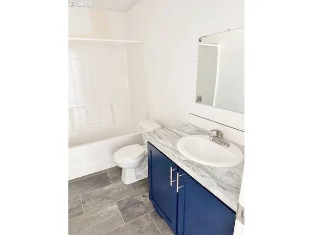 a bathroom with a granite countertop sink a toilet and a bathtub