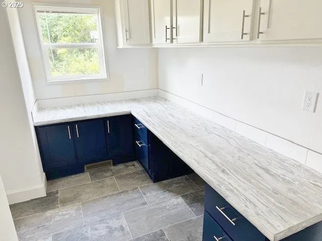 a kitchen with a sink window and cabinets