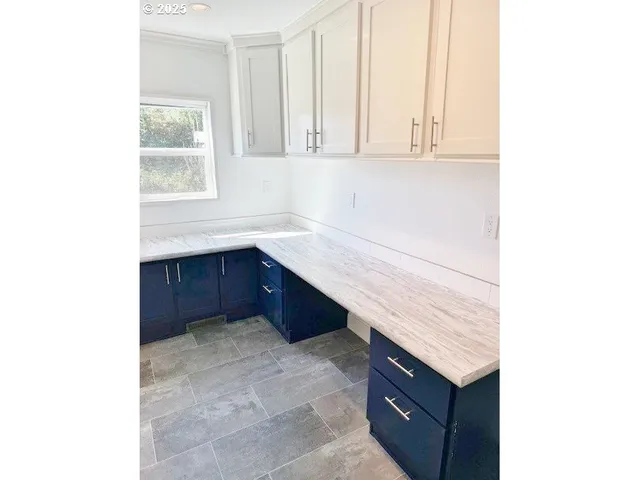 a kitchen with a sink cabinets and a window