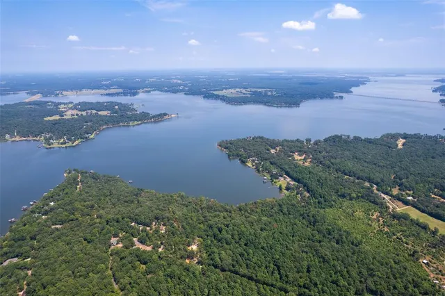 an aerial view of ocean and residential houses with outdoor space