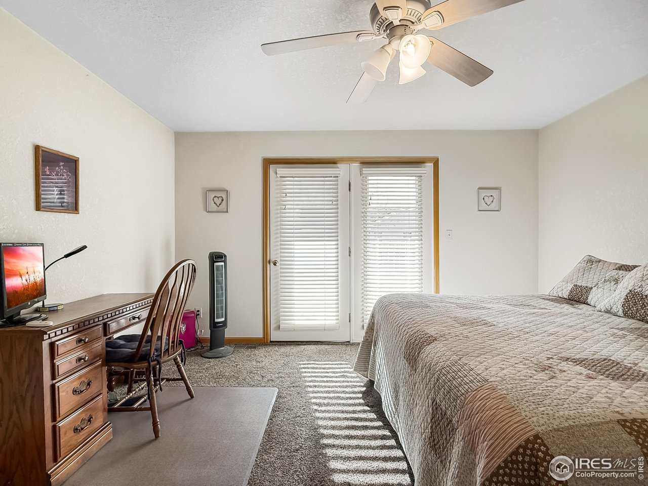 817 Mindy Circle, Unit B Sterling, CO 80751 - Photo 21 of 34 a bedroom with a bed a desk and chair with a bookshelf
