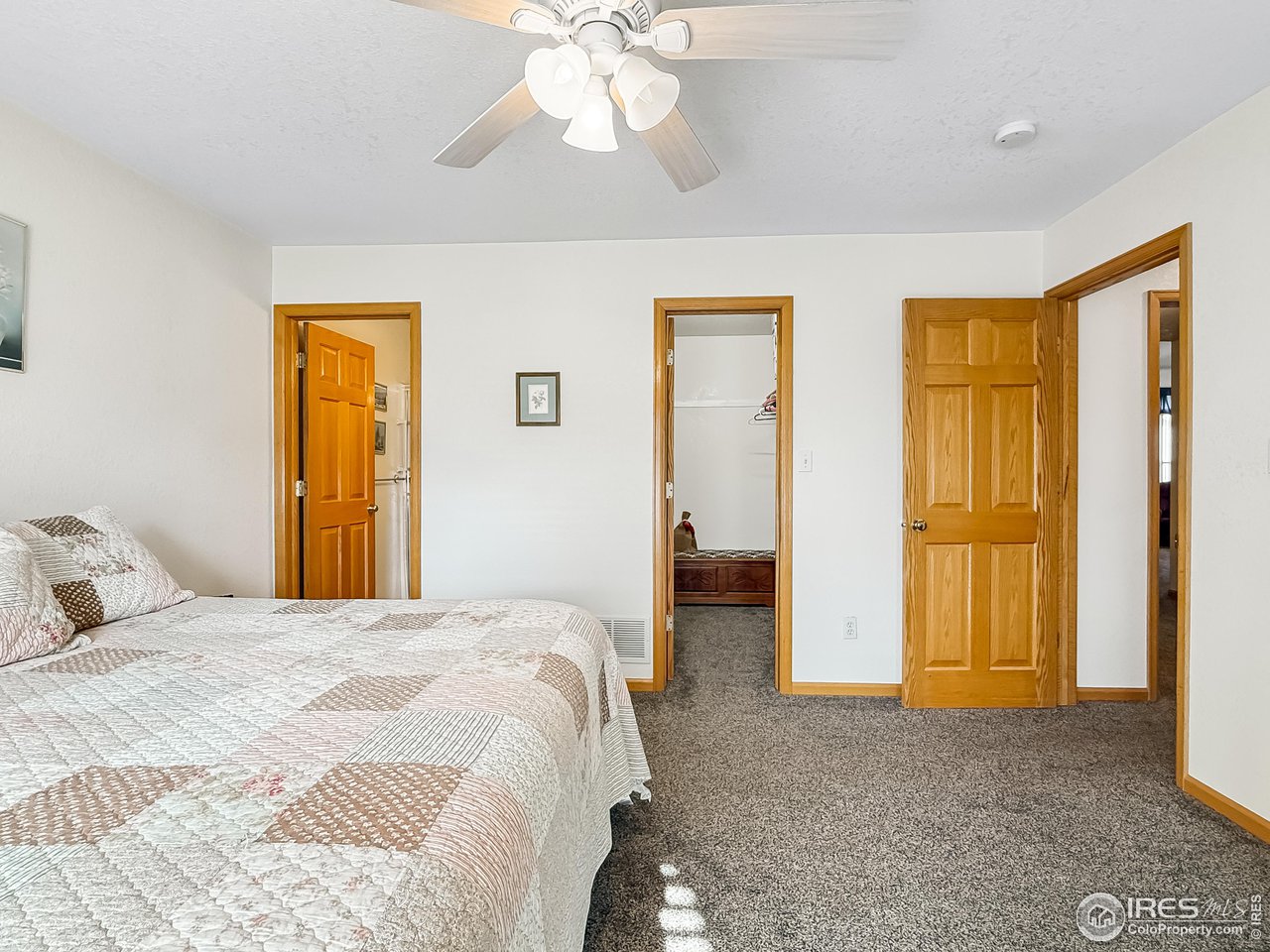 817 Mindy Circle, Unit B Sterling, CO 80751 - Photo 22 of 34 a bedroom with a bed and a chandelier
