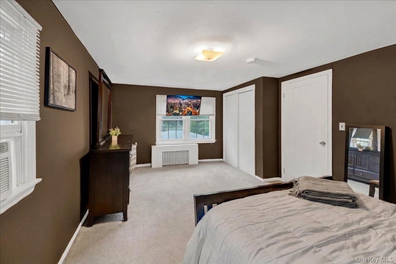 10 Susquehanna Road Ossining, NY 10562 - Photo 17 of 31 2nd floor bedroom featuring dual windows with blinds, a built-in closet with bi-fold doors, a single panel interior door, and light-colored carpeting
