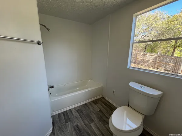 a white toilet sitting next to a bath tub