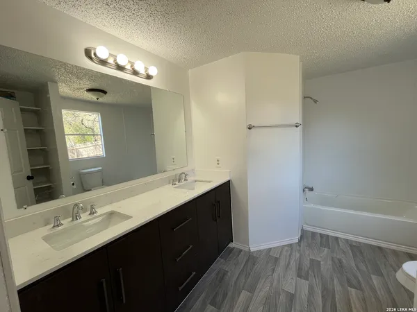 a bathroom with a double vanity sink a toilet and a mirror