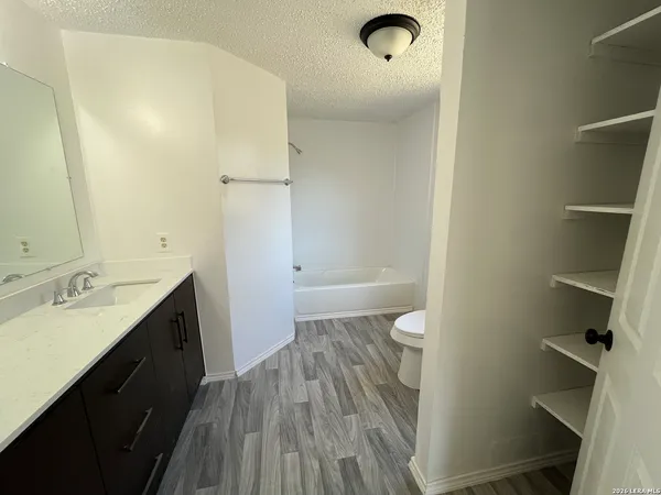 a bathroom with a granite countertop sink toilet and shower