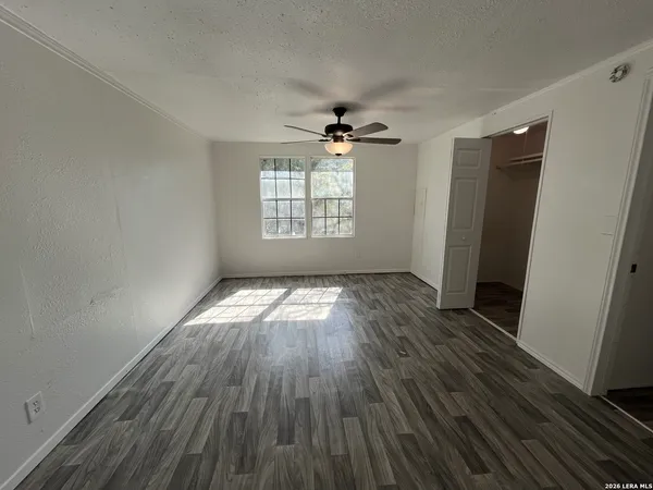 an empty room with wooden floor and windows